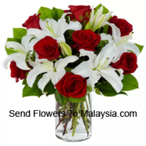 Красные розы и белые лилии с сезонными наполнителями в стеклянной вазе