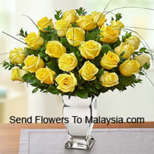 24 żółte róże z kilkoma paprotkami w szklanej wazie